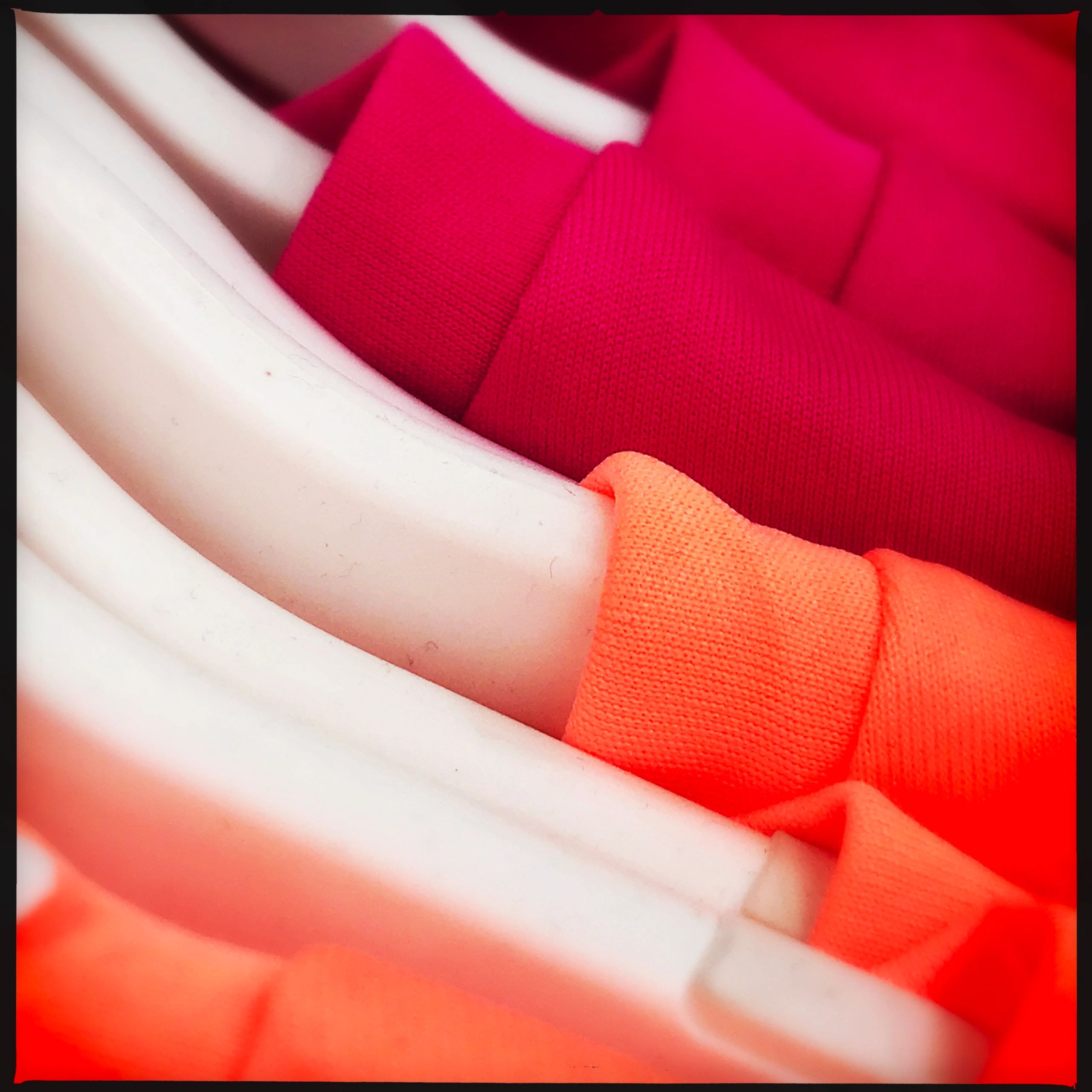 Bright colored custom shirts on hangers